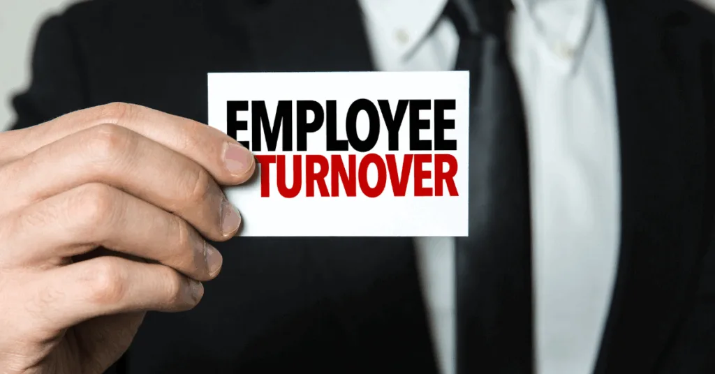 business owner holding a card that says "employee turnover"